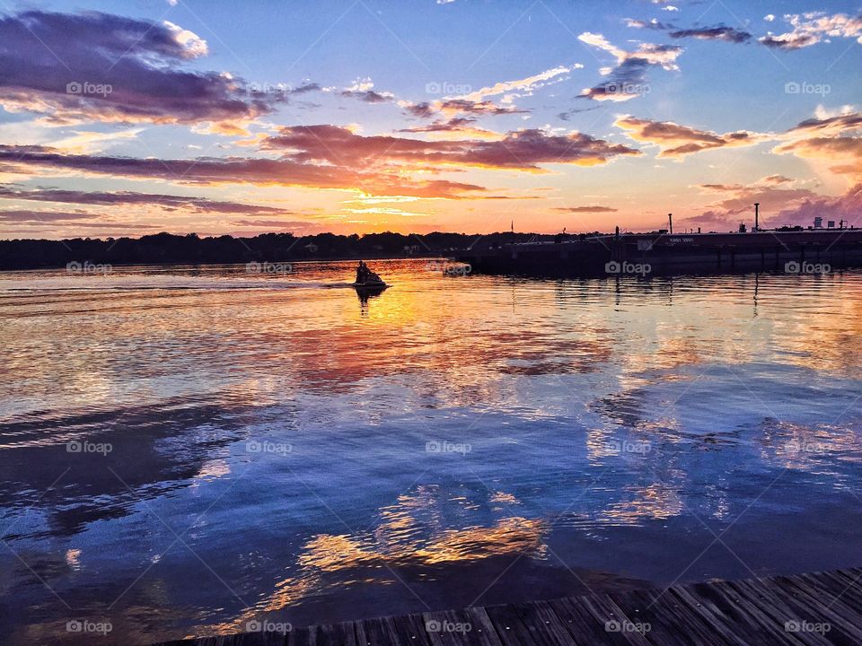 People jet skiing under dramatic sky