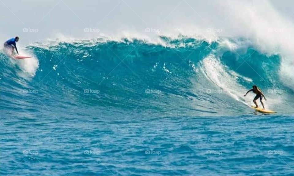 Two surfers in the blue sea of ​​Brazil