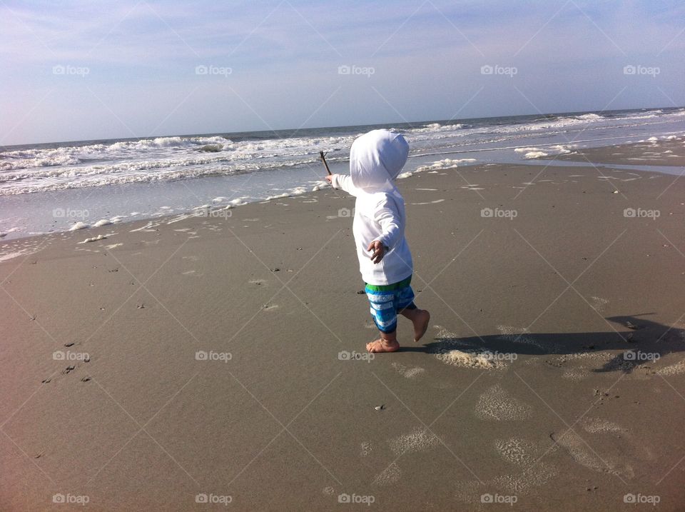Baby on the Beach. A 1-yr-old toddler walking on the beach. Photo taken at Folly Beach, South Carolina.