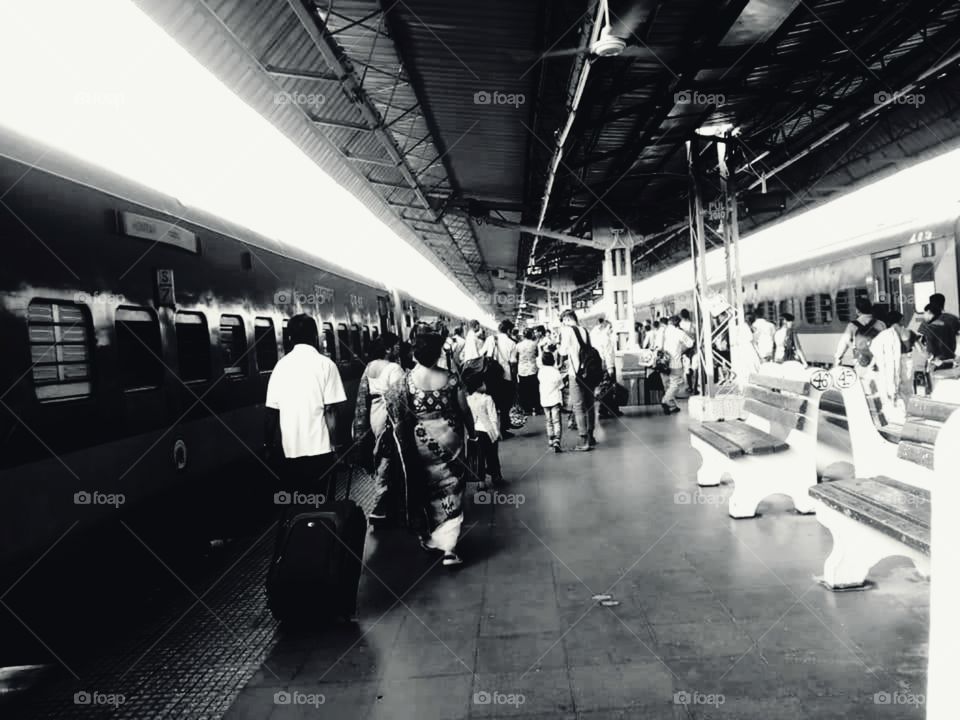 No Looking black."No regrets. 
Just hold on to life and move forward".A black & white potrait of a busy Railway platform where people hurrying to catch the train.