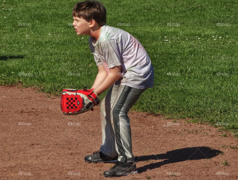 Boy Playing Shortstop In Little League. Waiting To Catch A Baseball