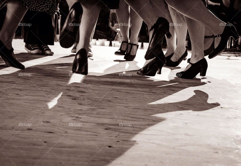 Sepia shot of the feet of women dancing and jumping at the Fisel dance competition in Rostrenen