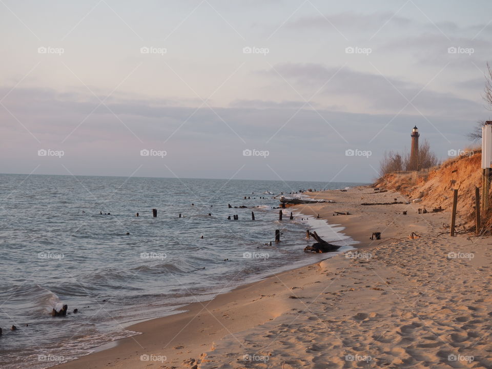 Lake Michigan‘s beach and a lighthouse in the background 