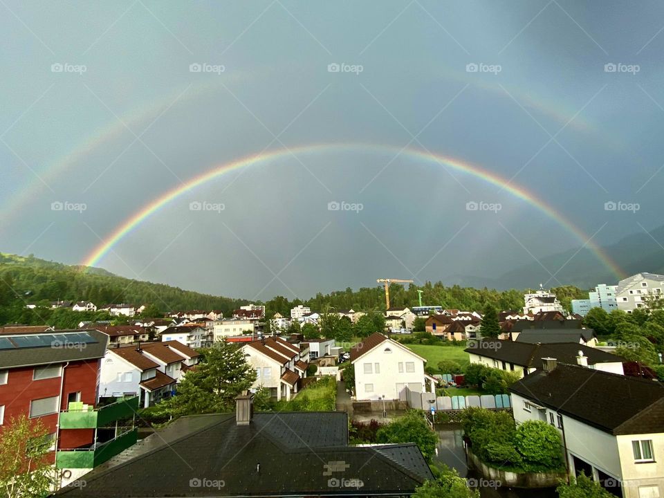 double beautiful rainbow after rain over the city in switzerland