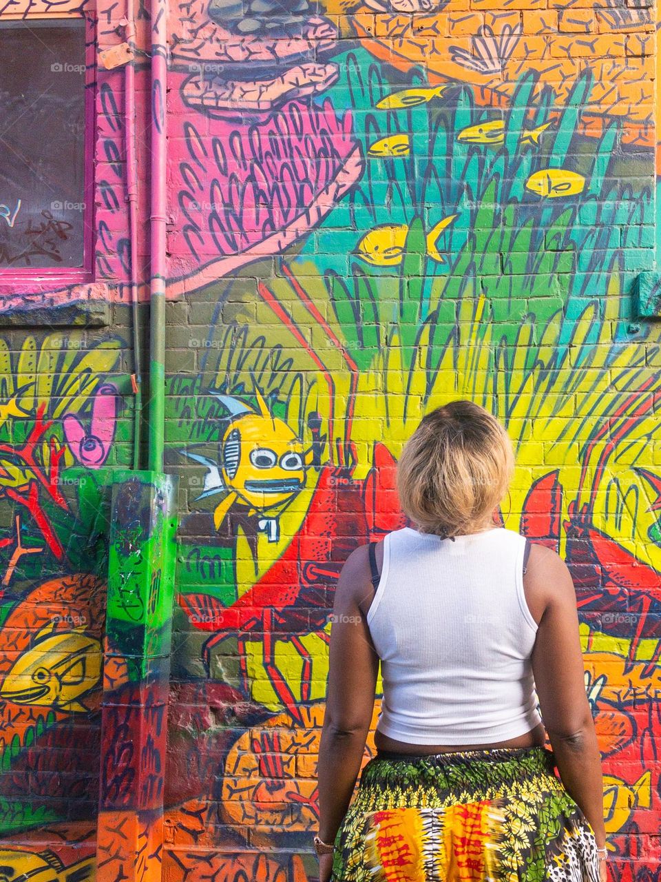 Girl looking at graffiti wall