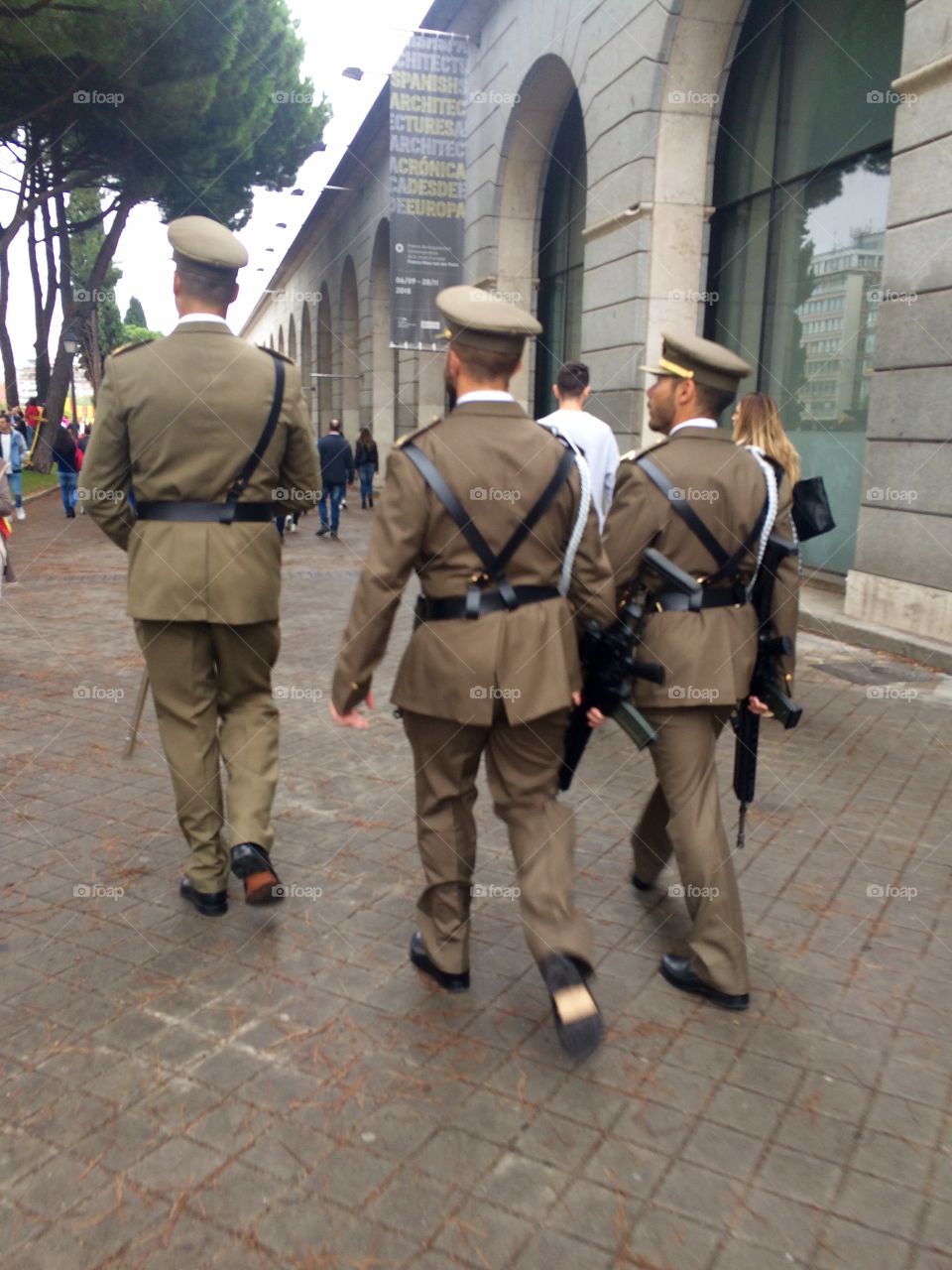 Three Spanish soldiers in full uniform walking down the streets of Madrid in Spain during national day celebrations 
