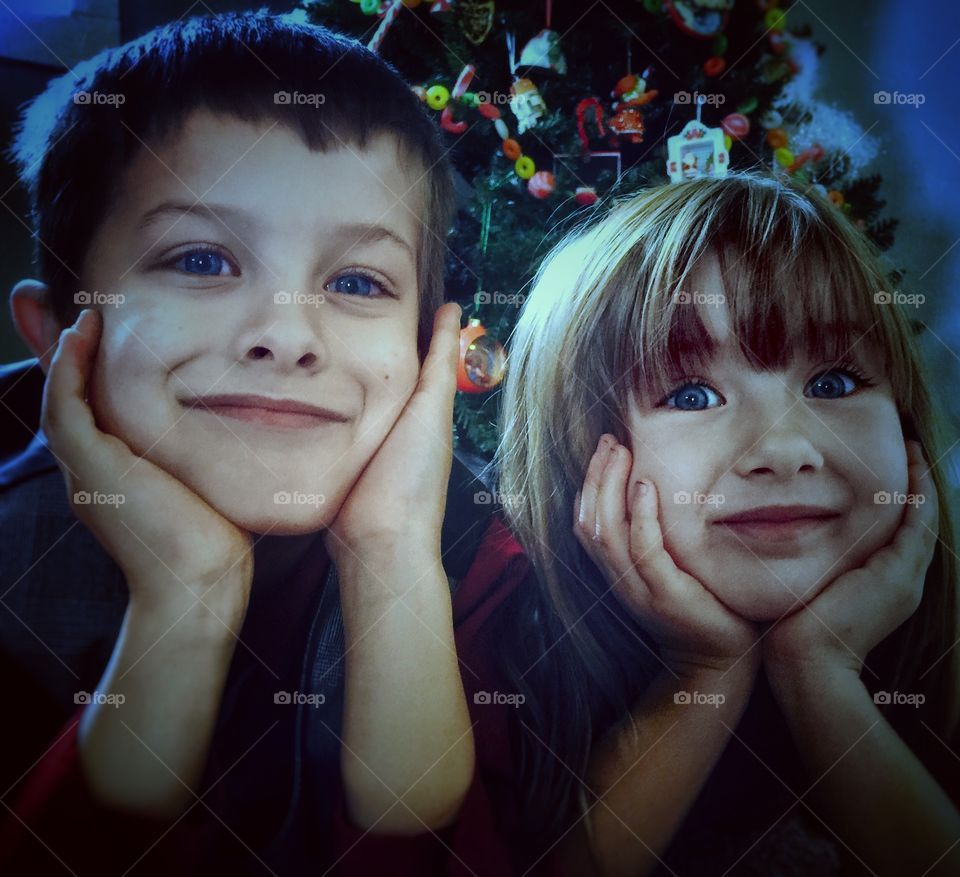 Portrait of little brother and sister hands on cheek
