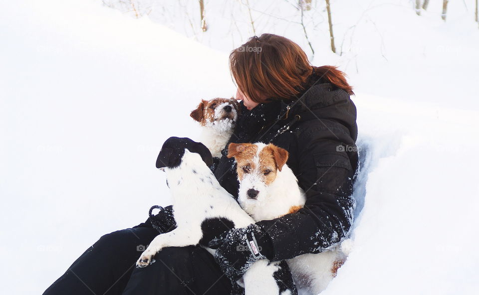 Young woman holding dogs in winter