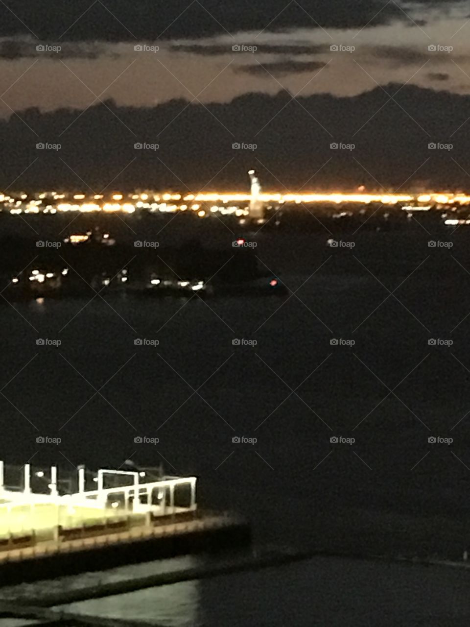 A corner of the illuminated metal railing of the luxury home’s terrace high up so the view is truly magnificent reaching far into the distance. Manhattan can be seen from here and parts of Brooklyn. 2017. Hypnotic Productions