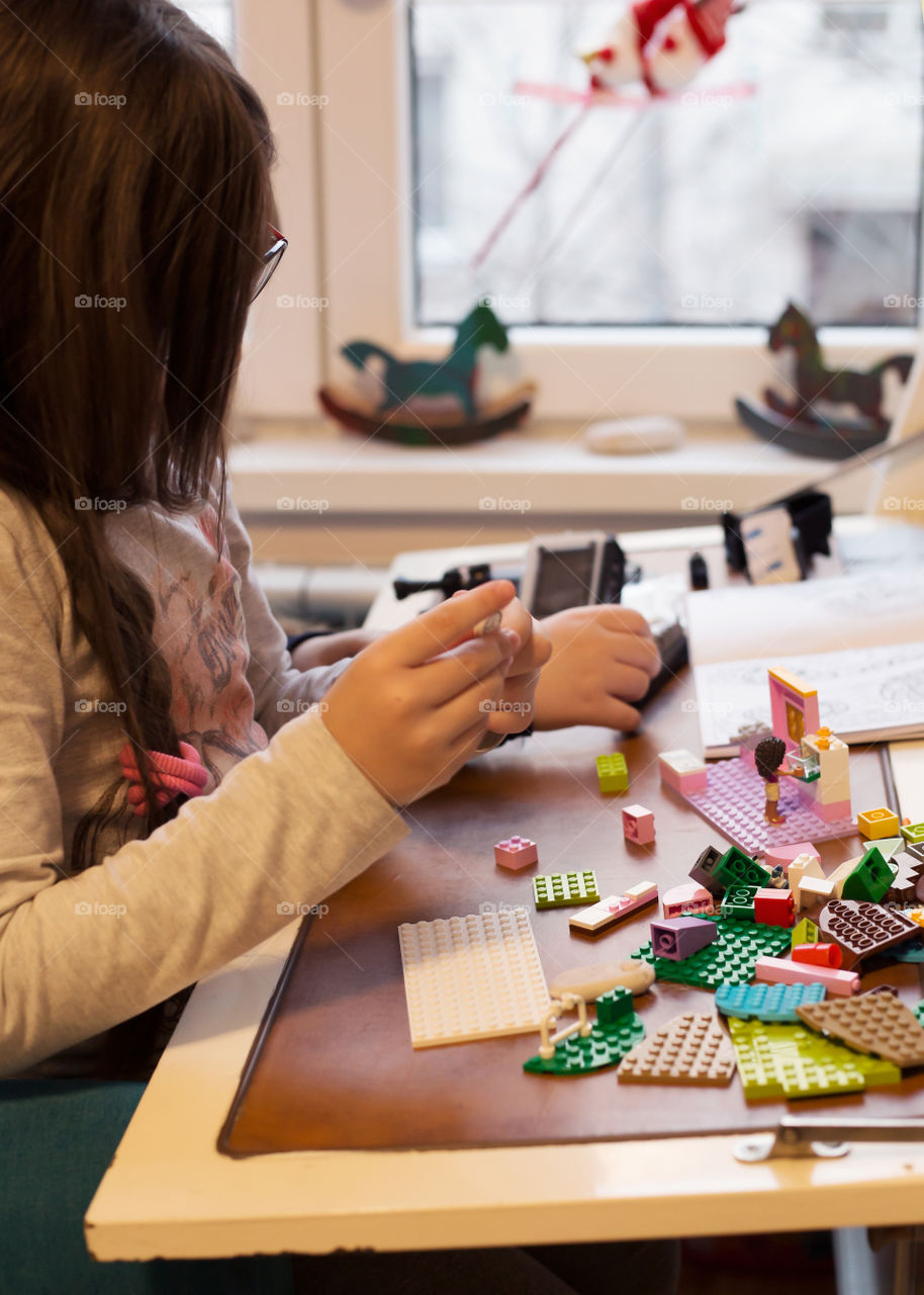 Little girl building while playing with blocks