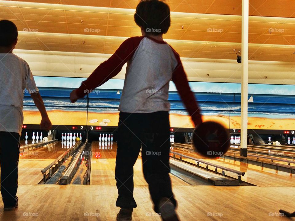 Boys At The Bowling Alley. Brothers Playing Indoor Sports
