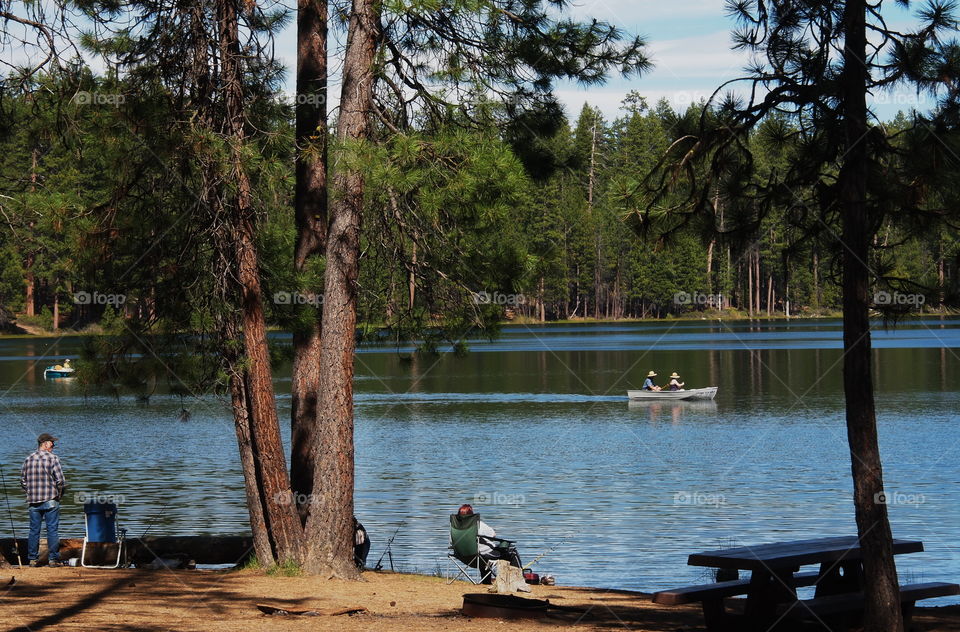 People fishing, boating, and walking enjoying a beautiful spring afternoon at South Twin Lake in the forests of Central Oregon. 