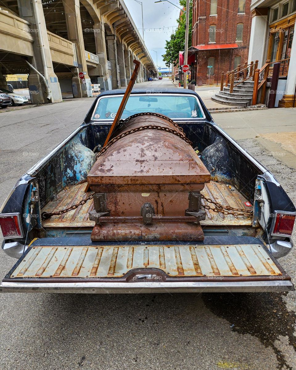 A classic Chevy El Camino holds the strange cargo of a large casket and a wooden framed mirror