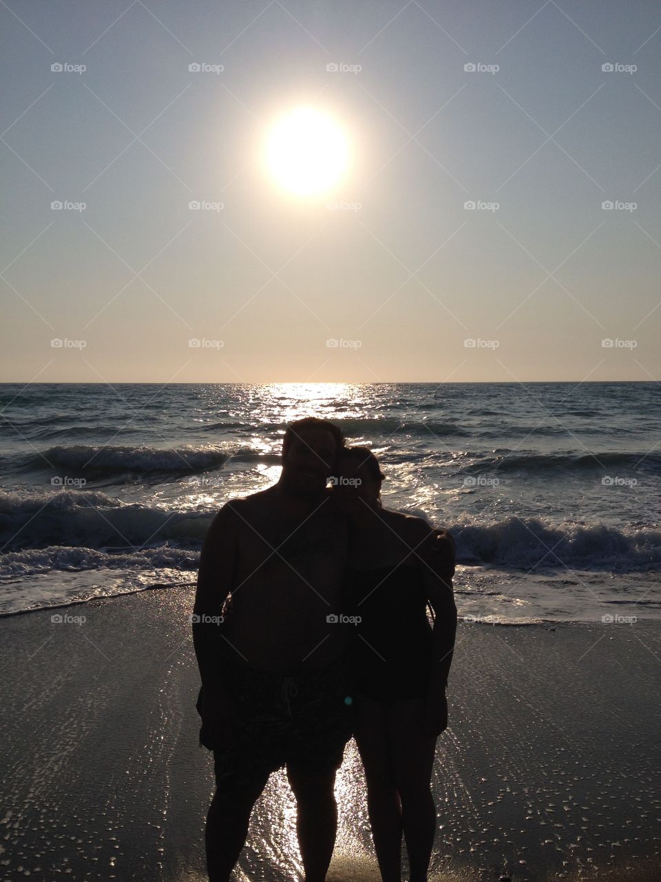 Silhouette of a couple standing in front of a beach in Rhodes, Greece at sunset
