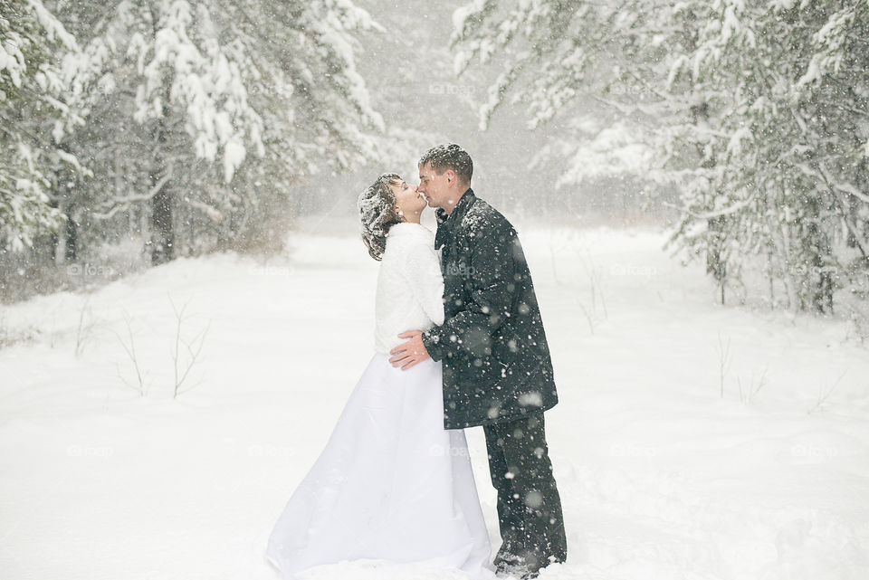 Side view of couple kissing in snowy weather