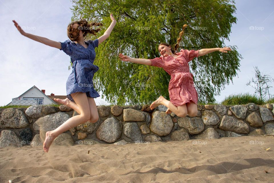 Happy teen Girls at the beach a summer day . Jumps around and having fun summerdays .