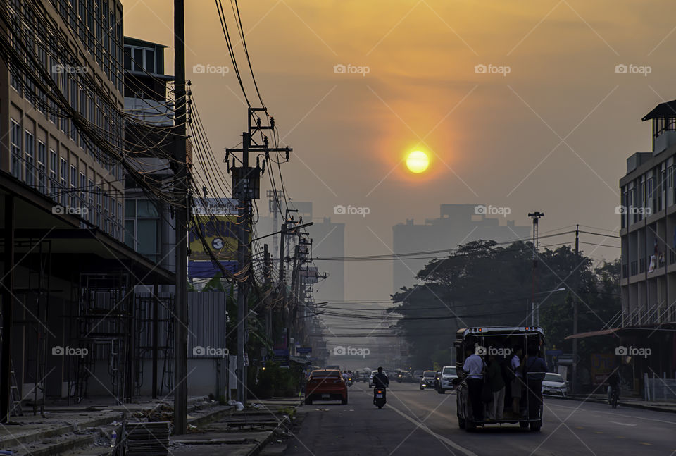 The early morning sunlight shining on buildings and the cars on the road at Bangyai City of Nonthaburi in Thailand.  January 11, 2019