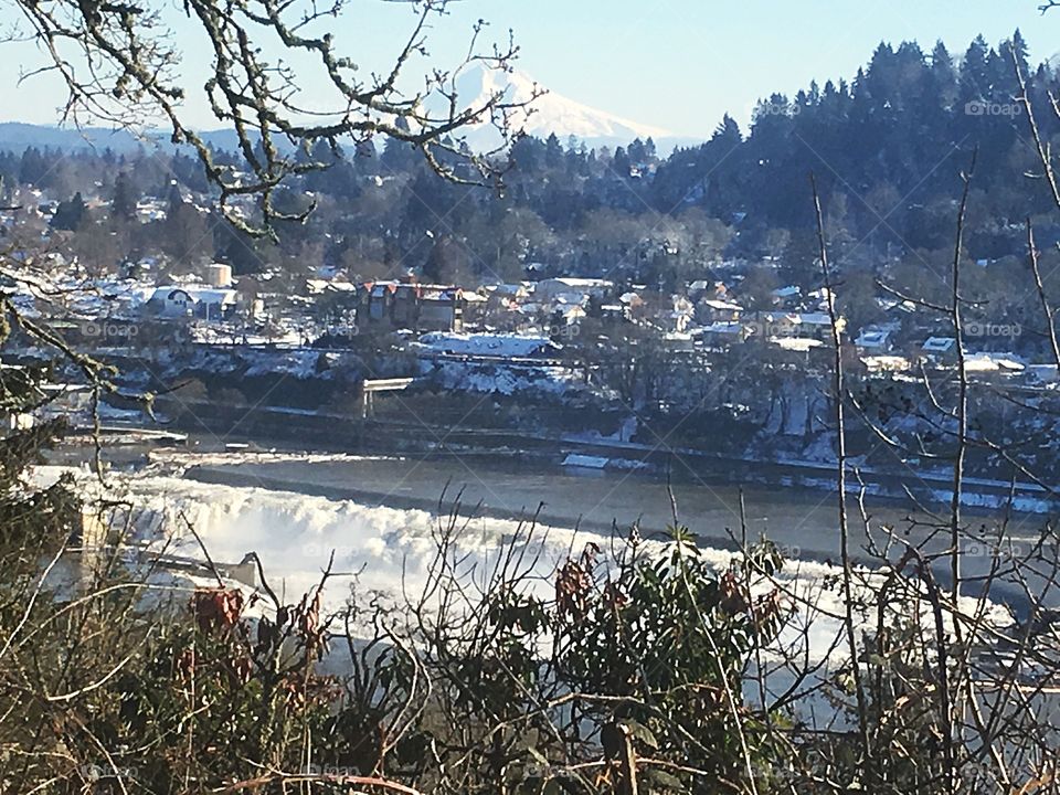 willamette falls during an iconic Portland snow event. A Beautiful waterfall with Mt. Hood peeking out in the background.