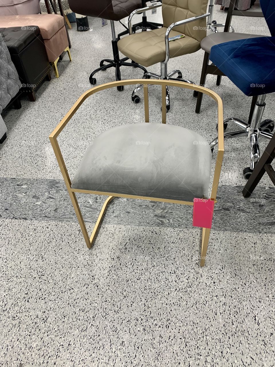 Gold chair with plush velvety seat cover displayed at the furniture store USA America 