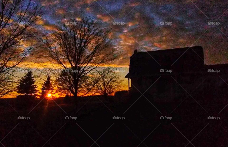 farmhouse silhouette at sunset