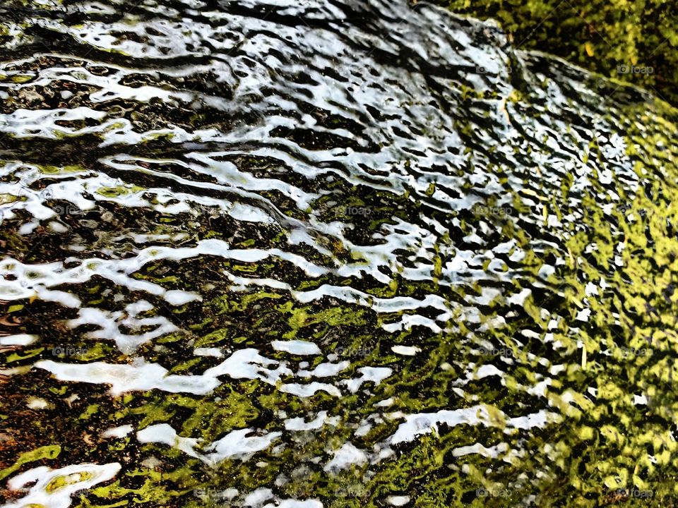 water flowing through top of rock