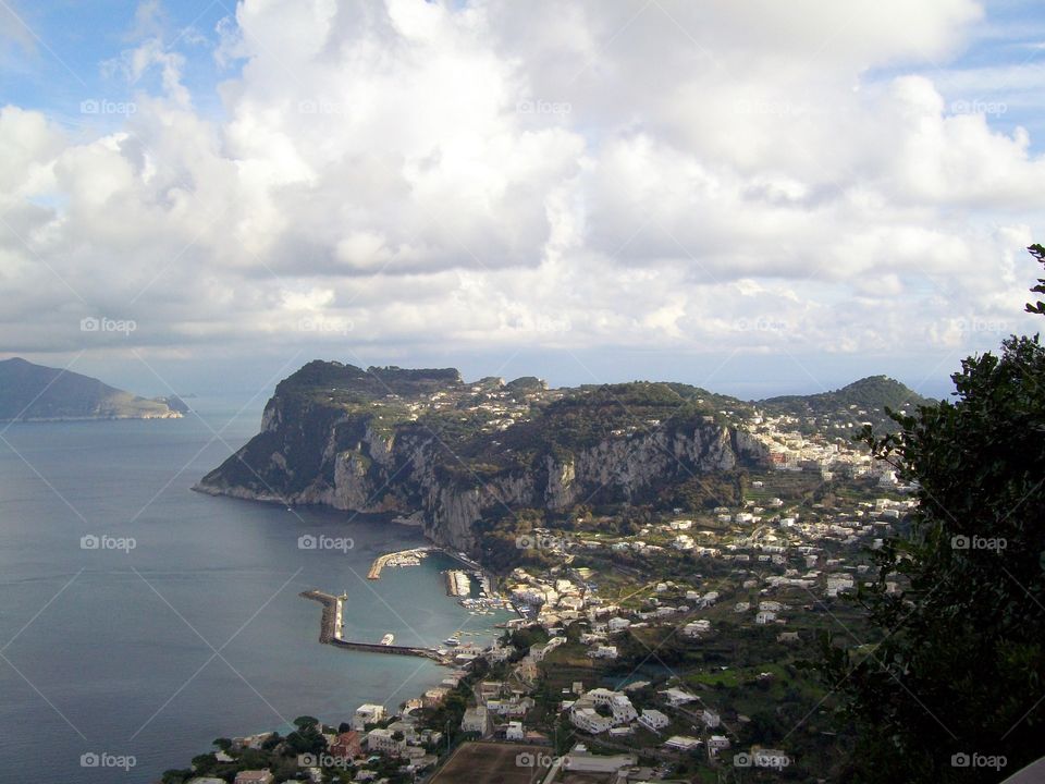 At one of the best lookout points on the island of Capri with big tufted clouds floating over this picturesque view