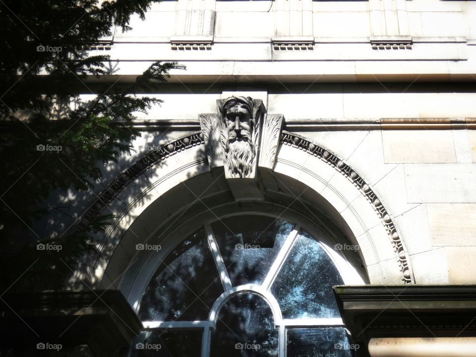Arched window with mans face on the top