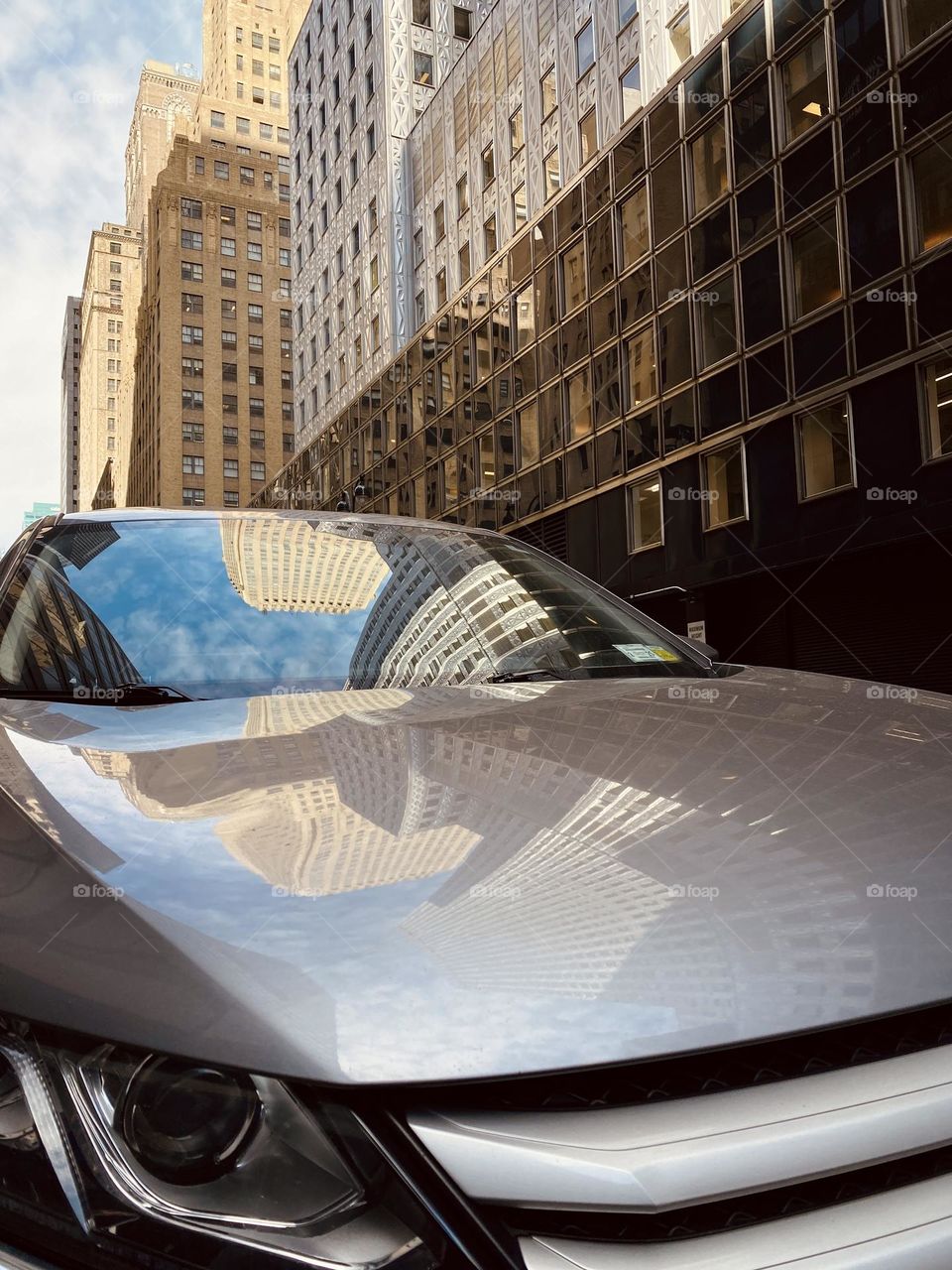 Corporate building and its reflection on the car. Skyscraper of Manhattan New York.