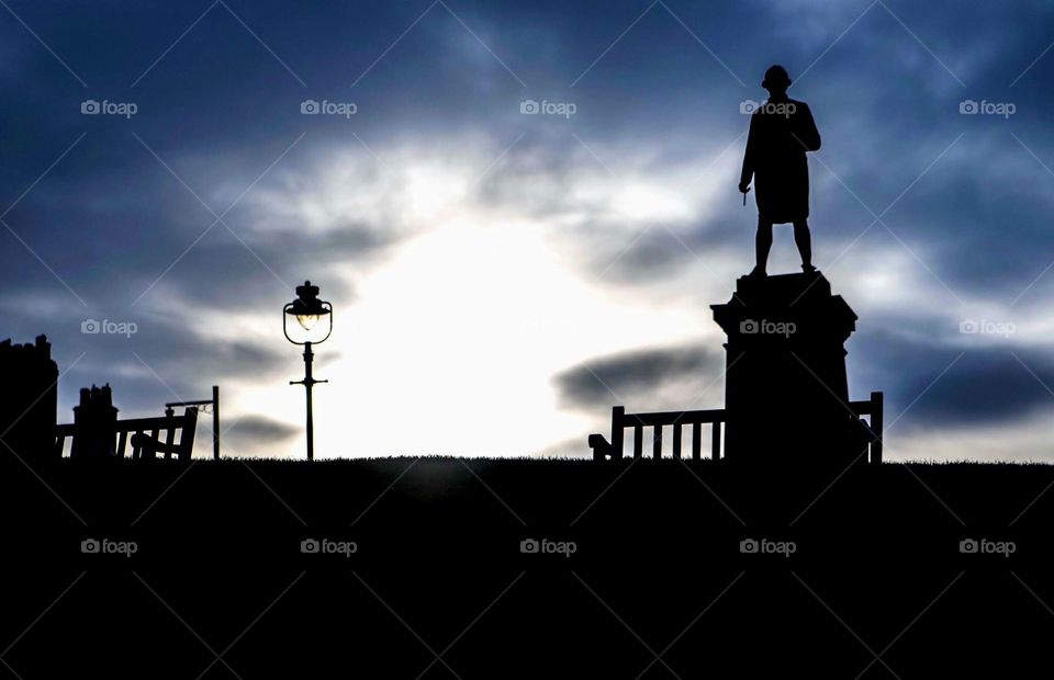 Whitby silhouette. Statue of the famous explorer captain James Cook. Looking out onto the beautiful North Yorkshire coast as the sun is beginning to set