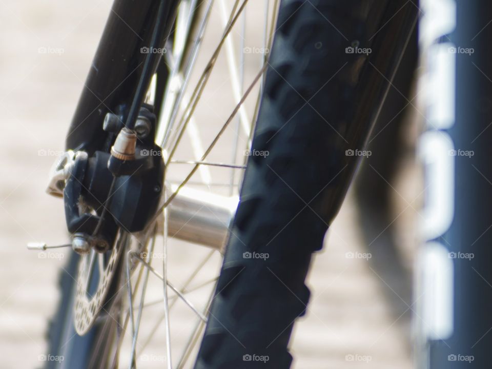 A picture of a bicycle wheel. The rubber of the tire and some parts of the bike are showing. It is a city bike but might as well have been a mountainbike