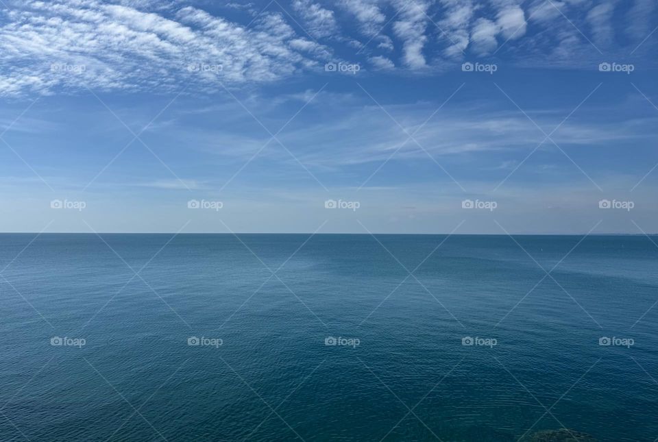 Vast ocean stretching out as far as the eye can see, creating an illusion with a straight horizon line