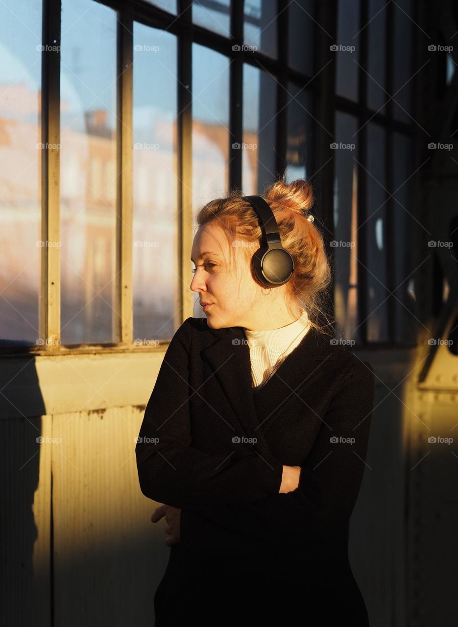 Young beautiful blonde girl with headphones in sunny day 