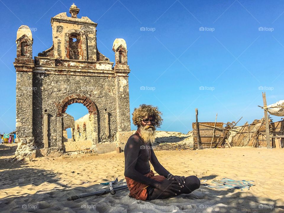 Portrait of an old man in a background of ruins of Dhanushkodi, a South Indian town hit by a massive storm and killed hundreds of people and made the town unliveable and this old man has a story to tell 