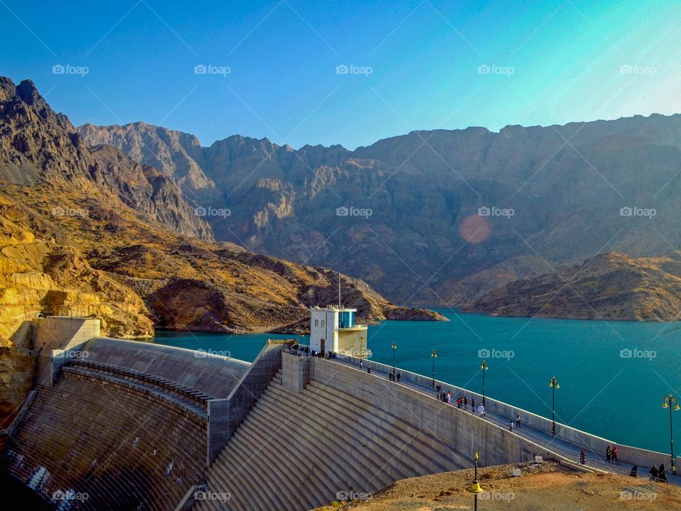 Wadi Dayqah Dam, Oman. Sunny day adding a natural lens flare effect, with mountains in the backdrop. 