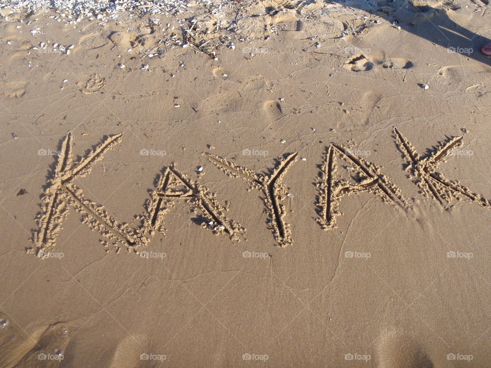 Kayak. Kayak written in sand 