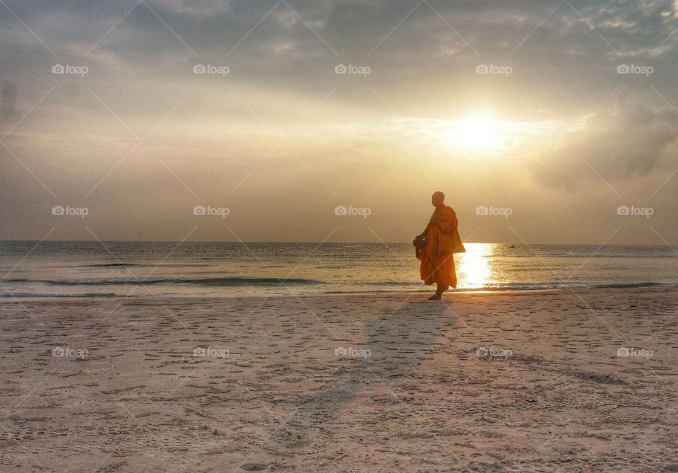 Morning Walk. While walking along the beach one morning, I saw this monk with the glory of the sunrise.