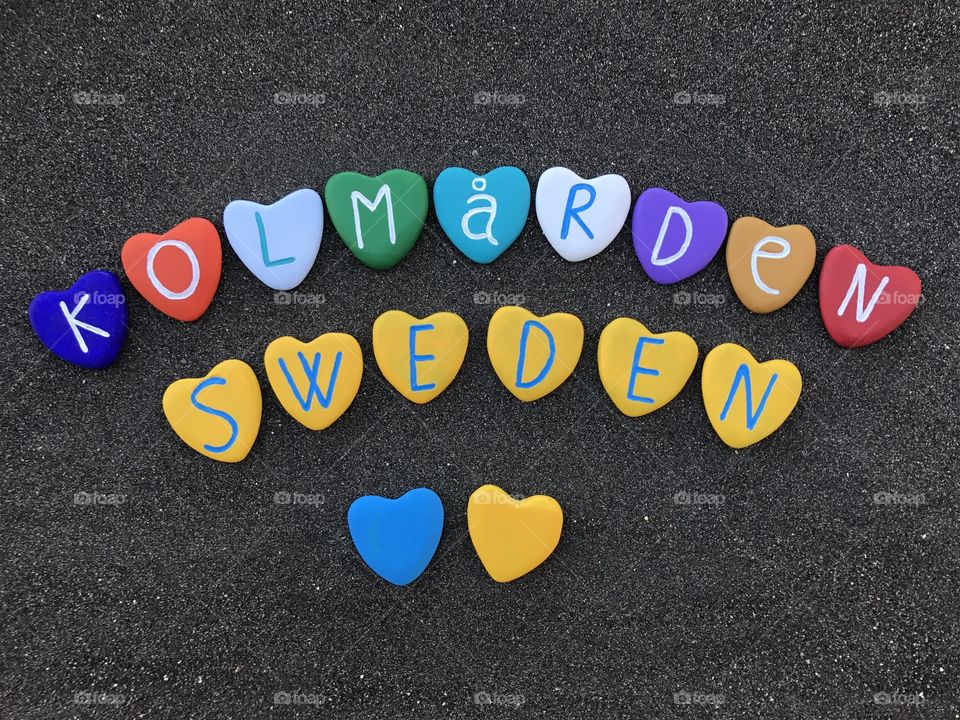 Visit Kolmården, Sweden, souvenir with colored heart stones over black volcanic sand