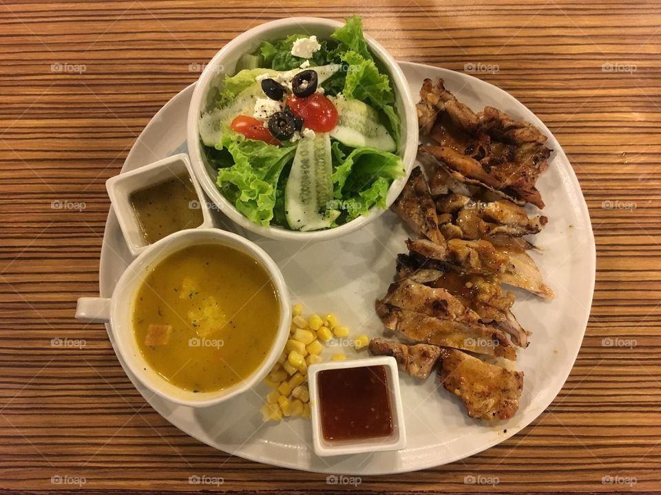A full healthy meal: salad, carrot soup, grilled spicy chicken