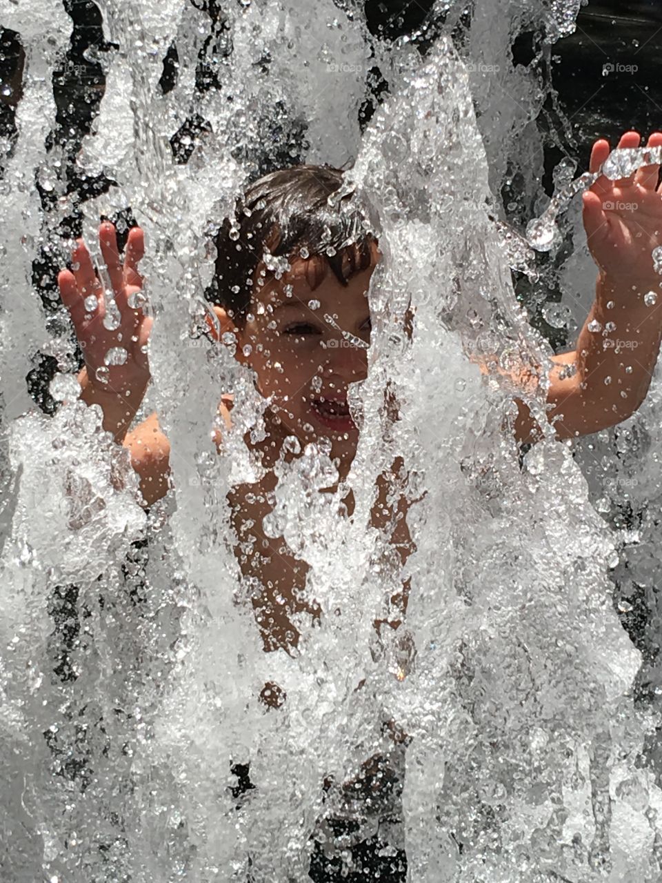 Boy playing in a splash pad.