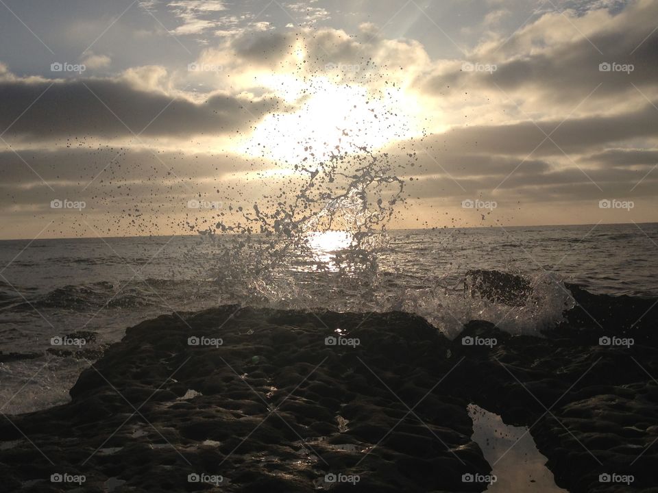 Splash. Taken on the coast of California, the waves crash against the rocky beach as the sun sets in the background. 