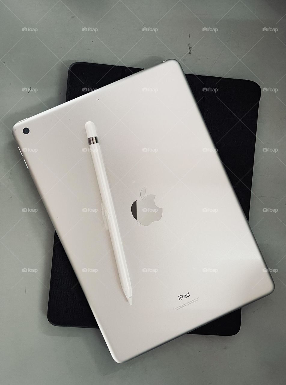 iPad and Apple pencil on table. View from top