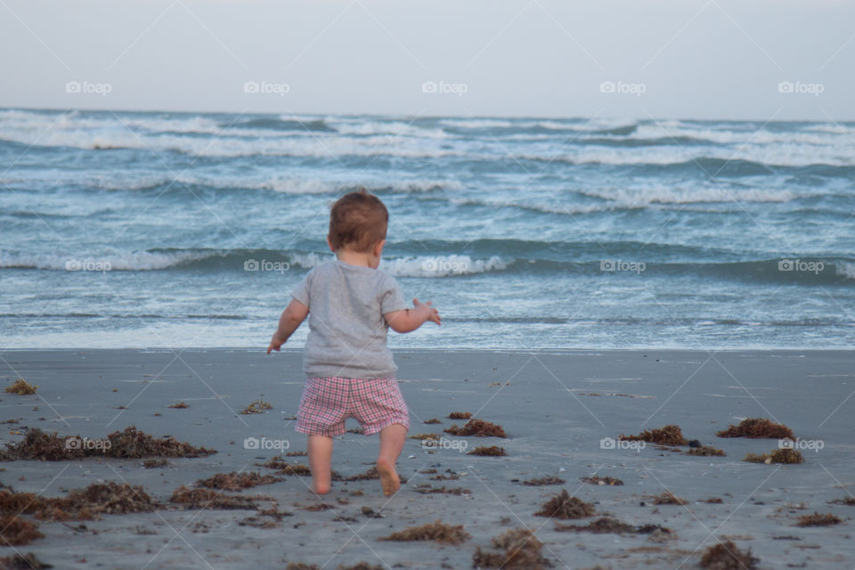 Rear view of baby walking at beach