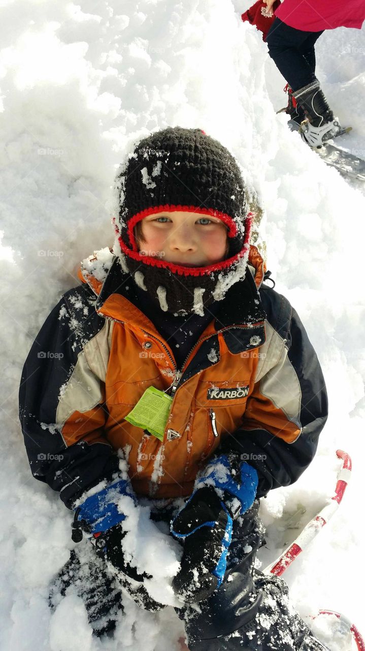 Boy in the snow with snowshoes