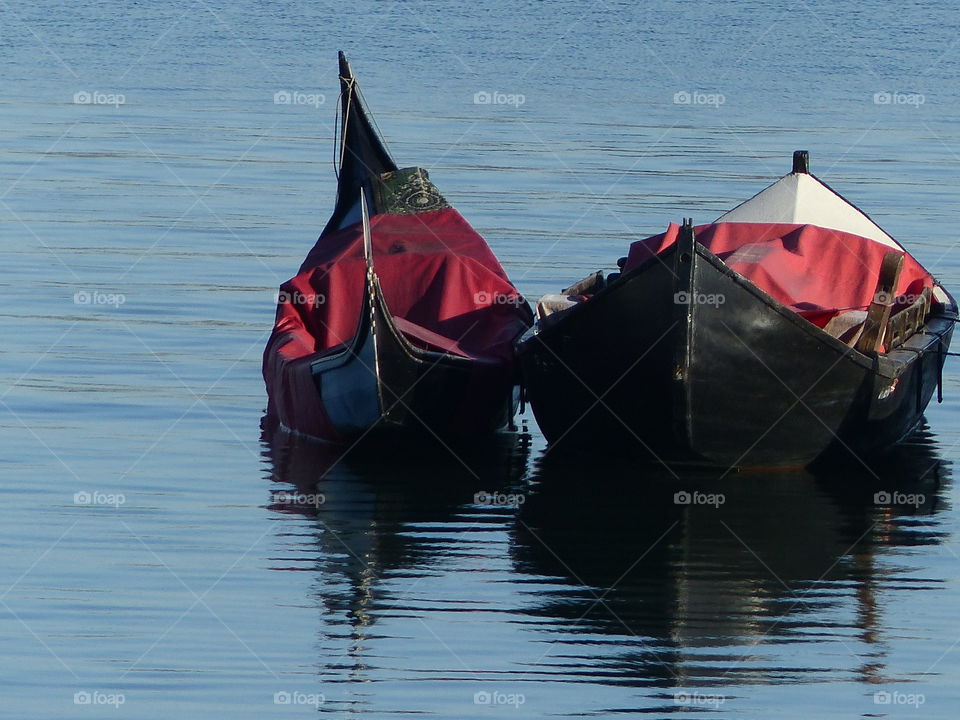 Two gondolas reflecting in water