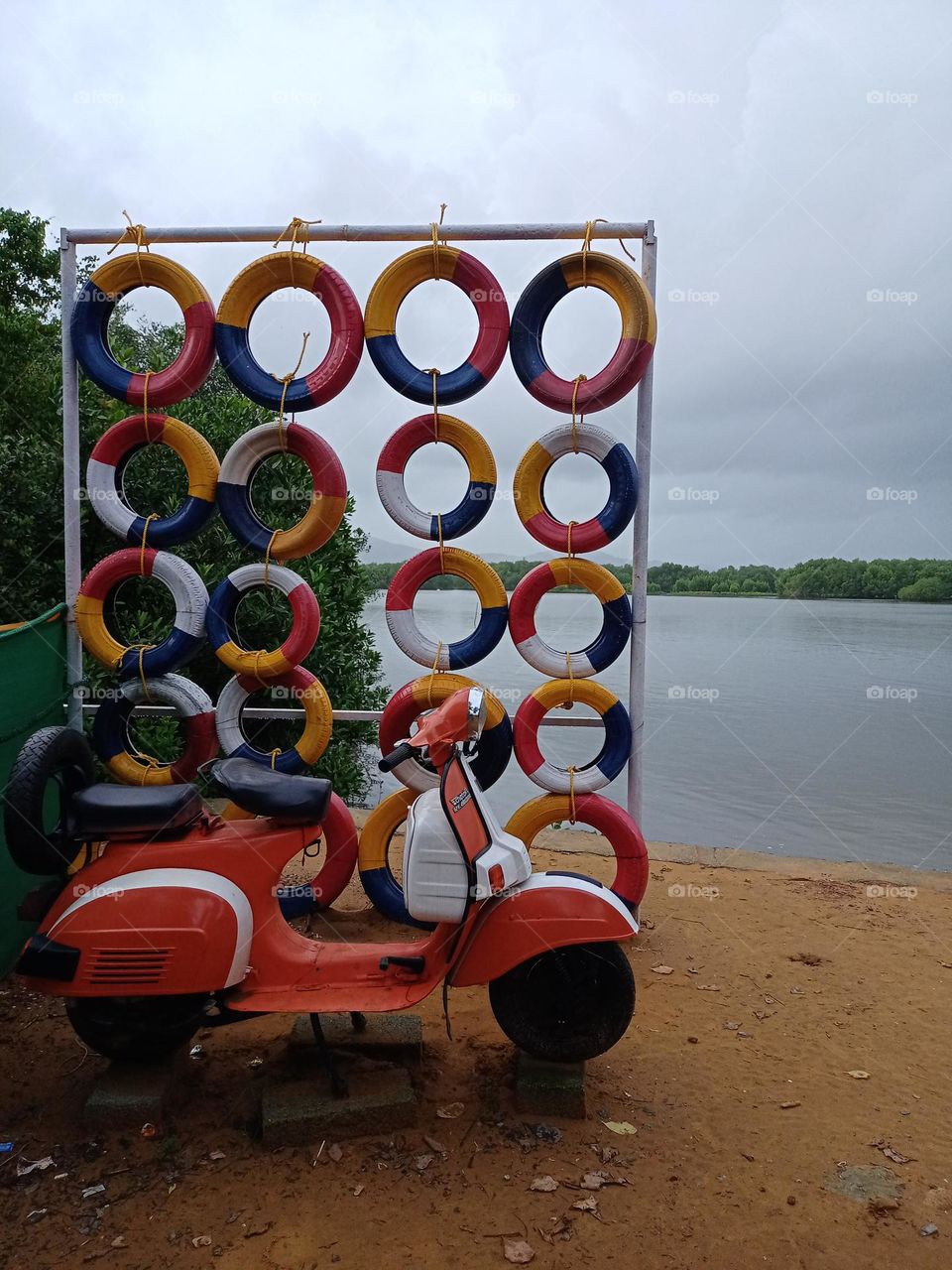 scooter red and white colour is on the bank the river nice view antique