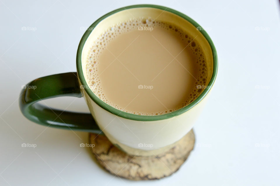 Mug of coffee on a natural wooden coaster