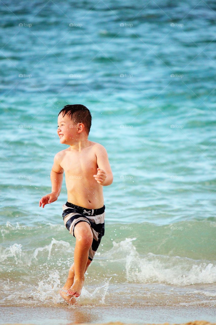 Happy boy running on beach