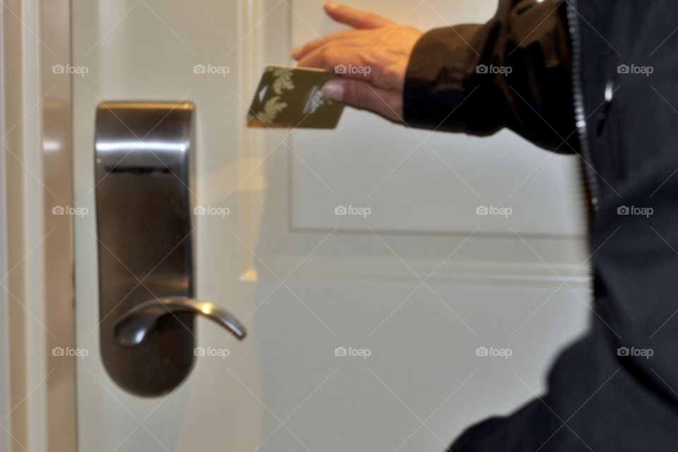A man getting ready to use his hotel room entry key card access. Security scan card for easy entry access!