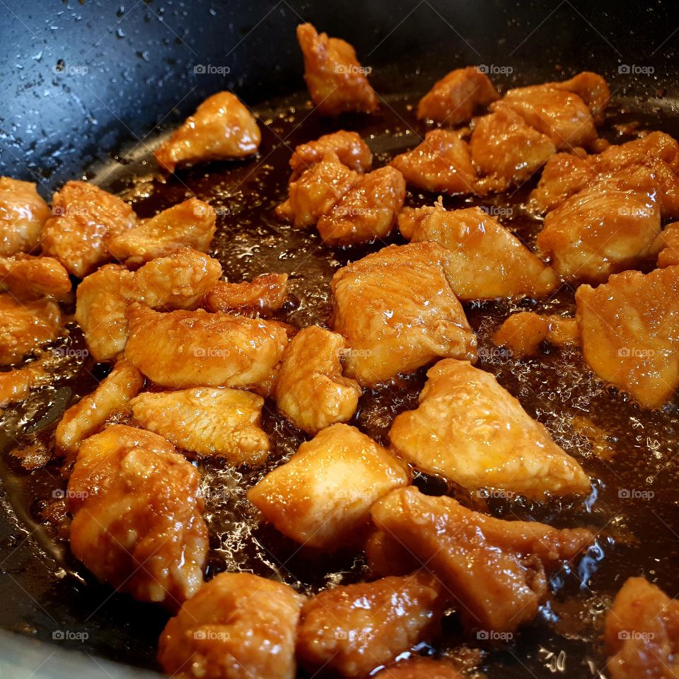Fried chicken in a frying pan.