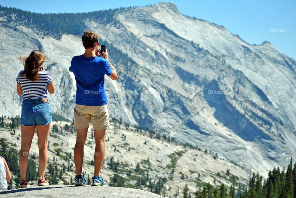 Traveller taking a photo of the view at Olmsted Point, Yosemite